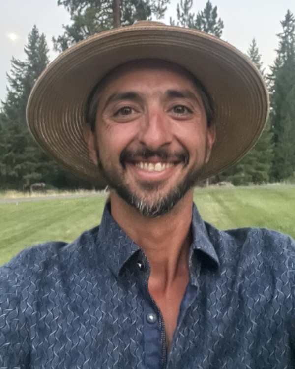 Josh Farmer, Director of Community and Brand, smiling outdoors in a sun hat.