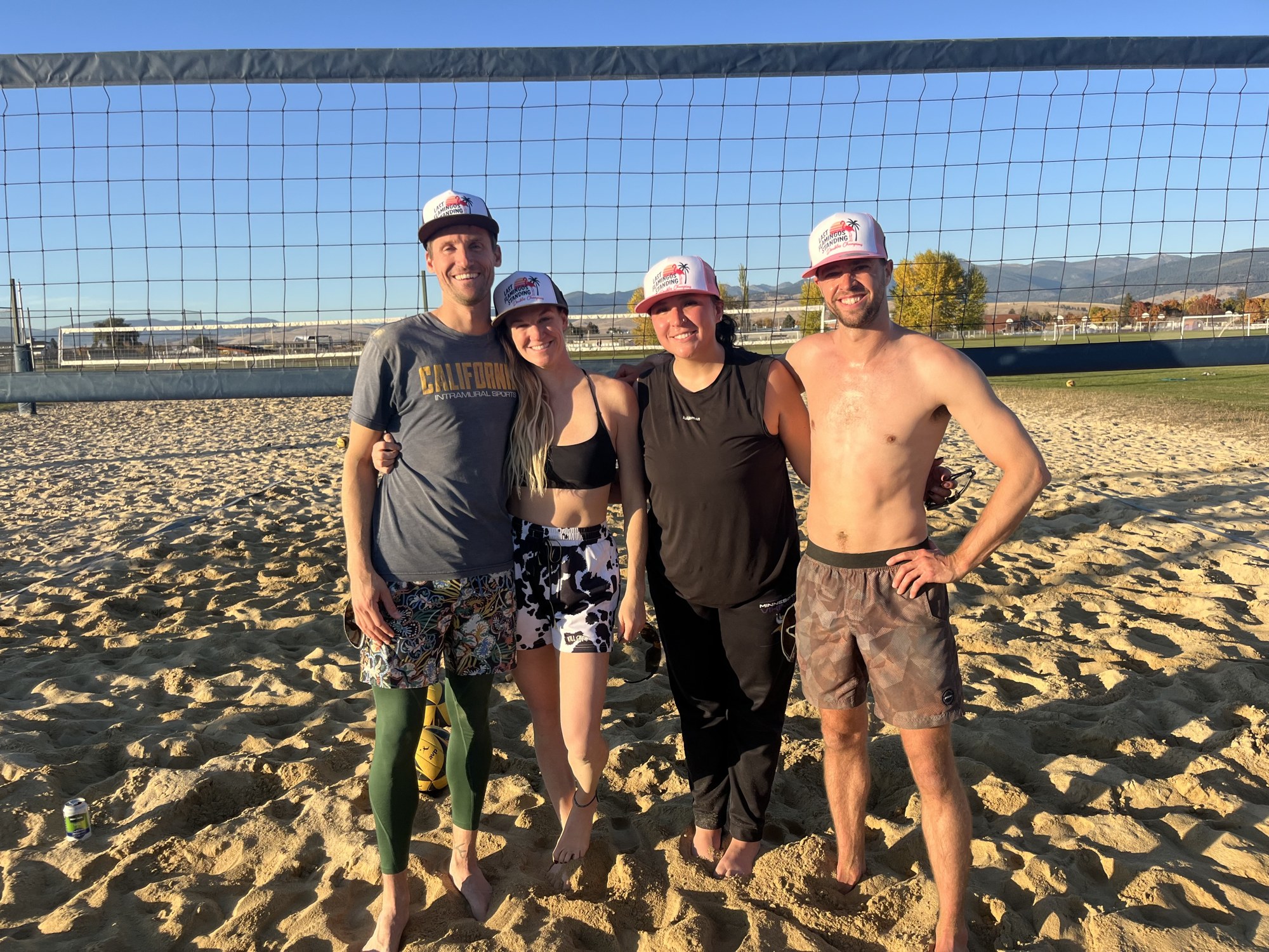 Four sand doubles winners standing together on the sand volleyball court at FlaminGlow.